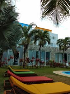uma fila de bancos coloridos em frente a um edifício em Apart Hotel Praia dos Carneiros Apto 101 em Praia dos Carneiros