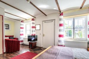 a bedroom with red and white curtains and a bed at Schloß Destille in Dormagen