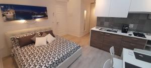 a small bedroom with a bed and a kitchen at BARBARA Classy Apartment 101 in Siracusa
