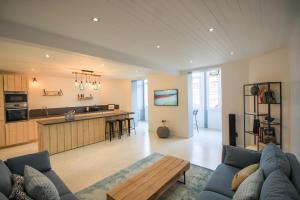 ein Wohnzimmer mit einer blauen Couch und einer Küche in der Unterkunft La Maison Bleue - En plein cœur d'Arcachon in Arcachon