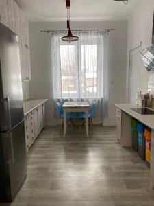 a kitchen with a table and blue chairs in it at Bon Voyage Apartments in Gdańsk