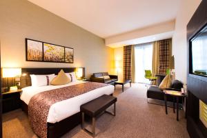 una camera d'albergo con un grande letto e un soggiorno di Holiday Inn London - Whitechapel, an IHG Hotel a Londra