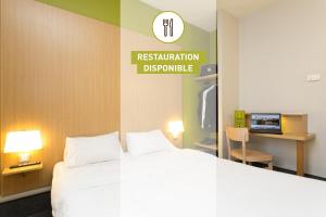 una camera d'albergo con un letto e un cartello che indica la riserva di restrizioni di B&B HOTEL Lyon Sud États-Unis a Vénissieux