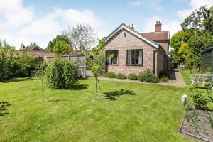 a brick house with a yard with green grass at Bakehouse in Great Ellingham