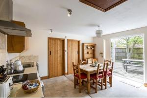 a kitchen and dining room with a table and chairs at Bakehouse in Great Ellingham