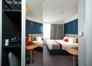 two images of a hotel room with two beds at Holiday Inn Express Burton on Trent, an IHG Hotel in Burton upon Trent
