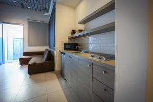 a kitchen with a sink and a couch in a room at Coral Suites in San Juan