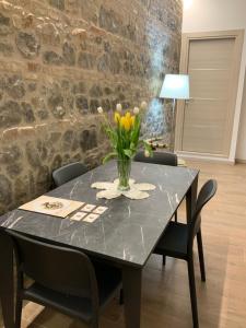 a dining room table with a vase of flowers on it at Residenza Pezzani in Parma