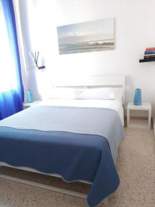 a bedroom with a large bed with a blue blanket at B&B Portarotese in Salerno