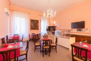 ein Esszimmer mit Tischen und Stühlen sowie eine Küche in der Unterkunft Hotel Jolì in Florenz