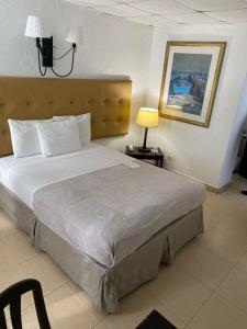 a bedroom with a large bed and a lamp at Coral by the Sea in San Juan