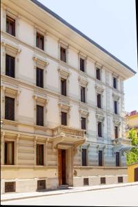 Großes weißes Gebäude mit Balkon in der Unterkunft Hotel Jolì in Florenz