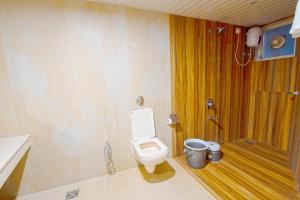 a bathroom with a white toilet and a shower at Kabila Agro Tourism in Mahabaleshwar