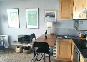 a kitchen with a table and a desk with chairs at Victoria Surf Biarritz 102 in Biarritz