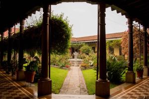 a garden with a fountain in the middle at Hotel Aurora in Antigua Guatemala