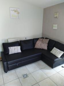 Gîte Les Framboisiers في نوفشاتو: أريكة جلدية سوداء في غرفة المعيشة