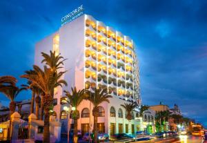 斯法克斯Concorde Sfax Centre的街道前有棕榈树的建筑