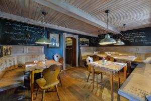 a restaurant with wooden tables and chairs and a chalkboard at RamsAu-das Gasthaus in Bad Heilbrunn