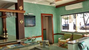 a kitchen with green walls and a view of a street at Pousada Porto do Itagua in Ubatuba