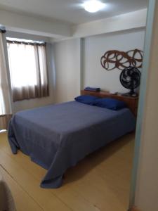 a bedroom with a blue bed and a window at Cantinho da Paz in Brasília