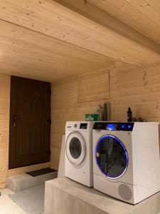 a washing machine in a room with a wooden ceiling at Lac et Montagne in Anthy