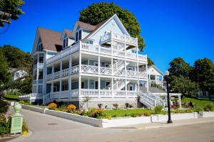 una grande casa bianca con un balcone bianco di Harbour View Inn a Mackinac Island