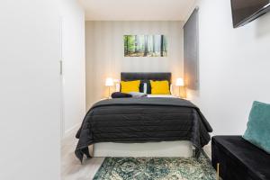 a bedroom with a black bed and yellow pillows at Madrid Rio Apartment in Madrid