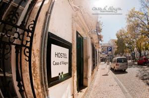 een bord aan de zijkant van een gebouw op een straat bij Hostel Casa d'Alagoa in Faro
