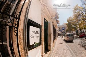 un panneau sur le côté d'un bâtiment dans une rue dans l'établissement Hostel Casa d'Alagoa, à Faro