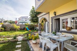 a patio with a table and chairs and a yard at T2 Anastácio com vista Jardim in Olhos de Água