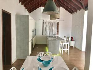 una cocina con una mesa blanca con platos. en Villa La Charlatana, en Caleta de Fuste