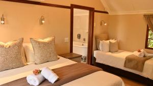 a hotel room with two beds and a mirror at Lamor Guest House in Middelburg
