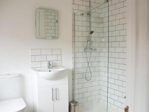 a bathroom with a glass shower and a sink at Corner House Apartment in Worthing