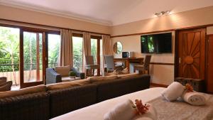 una camera con divano e un soggiorno con TV di Lamor Guest House a Middelburg