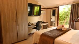 a hotel room with a bed and a desk and a window at Lamor Guest House in Middelburg