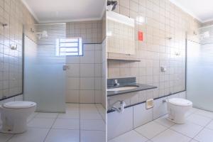 a bathroom with a toilet and a sink at Hotel Deck Rio in Icém