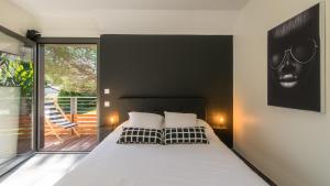 a bedroom with a large bed and a balcony at Villa Sunshine avec Jacuzzi Privatif in Sarlat-la-Canéda