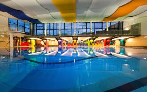 
a swimming pool filled with lots of people in it at Appartement Living Schönwies in Zell am See
