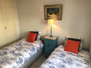 1 dormitorio con 2 camas y mesita de noche con lámpara en Apartamento VenAVera Playa Jardines de Nuevo Vera M1-1B Primera Línea, en Vera