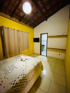 a bedroom with a bed and a yellow wall at Alto do Marinas in Angra dos Reis