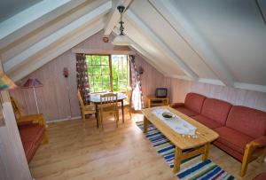 a living room with a red couch and a table at Westerås Gard in Geiranger