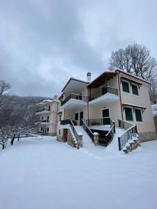 a large house with snow in front of it at Nefeles in Neochori