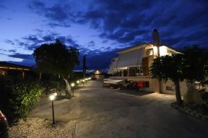 a street at night with a house and lights at AK VILLAGE ROOMS in Drepana