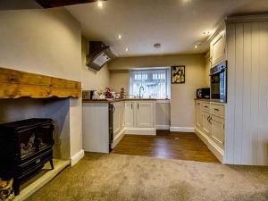 eine große Küche mit einem Kamin und einem Herd in der Unterkunft Owl Cottage in Keighley