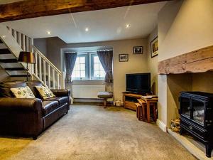 ein Wohnzimmer mit Couch und Kamin in der Unterkunft Owl Cottage in Keighley