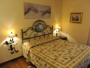 a bedroom with a bed and two lamps and a clock at Borgo D'Asolo in San Vito Di Altivole