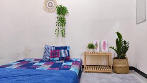 Dormitorio con cama y macetas en Surabaya Homey near ITS, en Surabaya