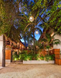 a building with trees and plants in front of it at Kin Ha Tulum Hotel in Tulum
