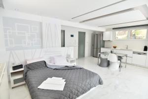 a bedroom with a large bed and a kitchen at Alpha Delta Pool Suite in Paleo Tsifliki
