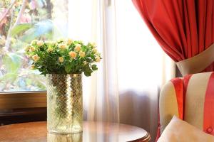 Don Pio في مدريد: مزهرية من الزهور تجلس على طاولة بالقرب من النافذة